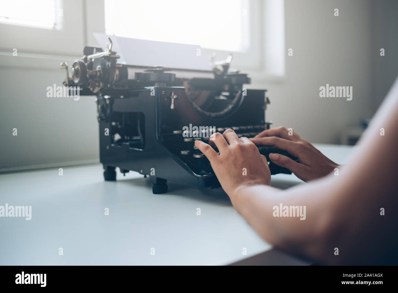 Close up di mani femminili digitando su una macchina da scrivere Foto Stock