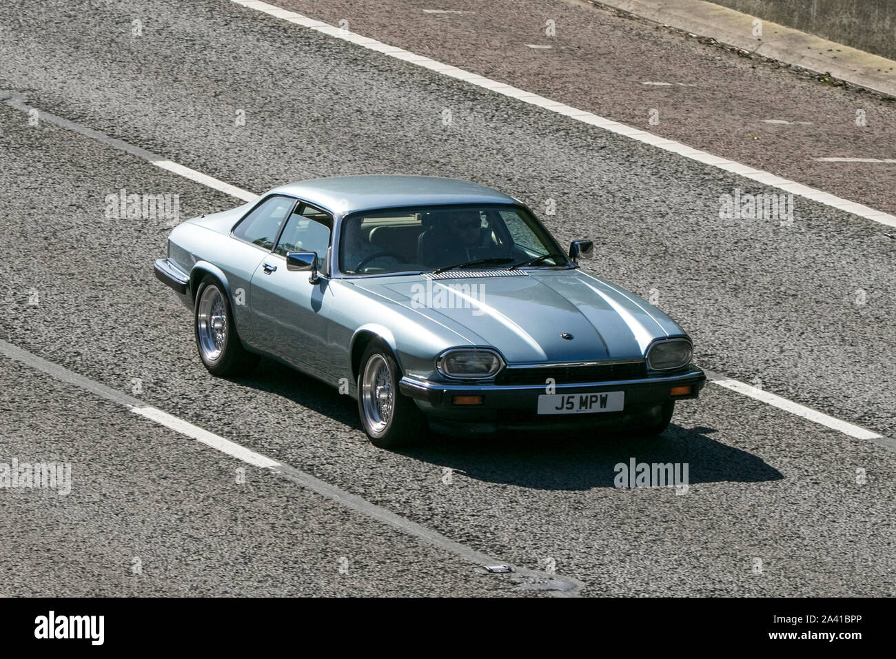 1991 blue Jaguar XJ-S 4.0; Viaggiare sulla autostrada M6 vicino a Preston nel Lancashire, Regno Unito Foto Stock