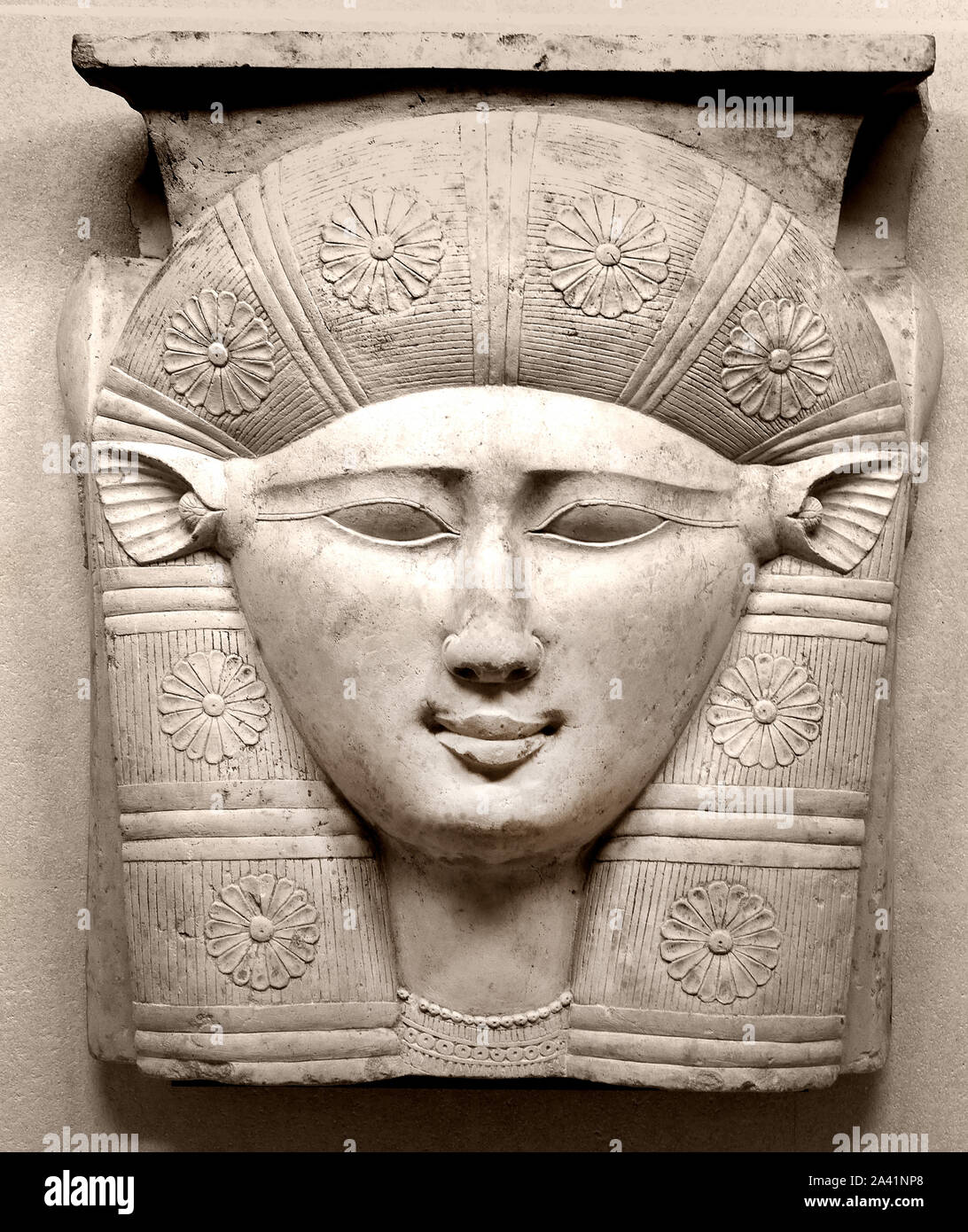 Il volto della dea Hathor, mucca con le orecchie del III secolo A.C. frammento di capitello di una colonna calcarea egiziano Egitto Foto Stock