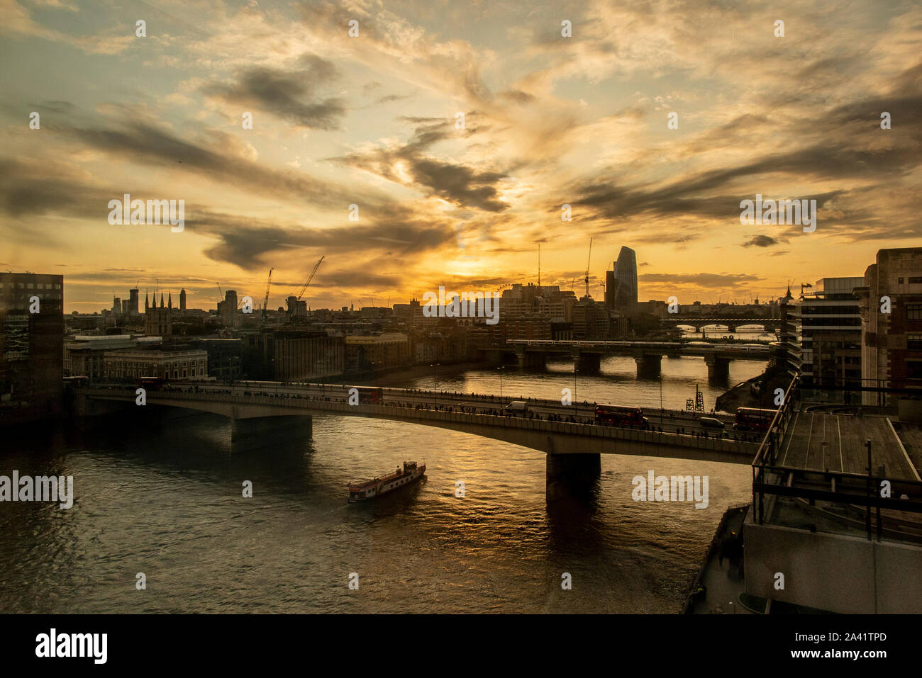 Fine della giornata lavorativa e pendolari a piedi oltre il Ponte di Londra come il sole tramonta Foto Stock