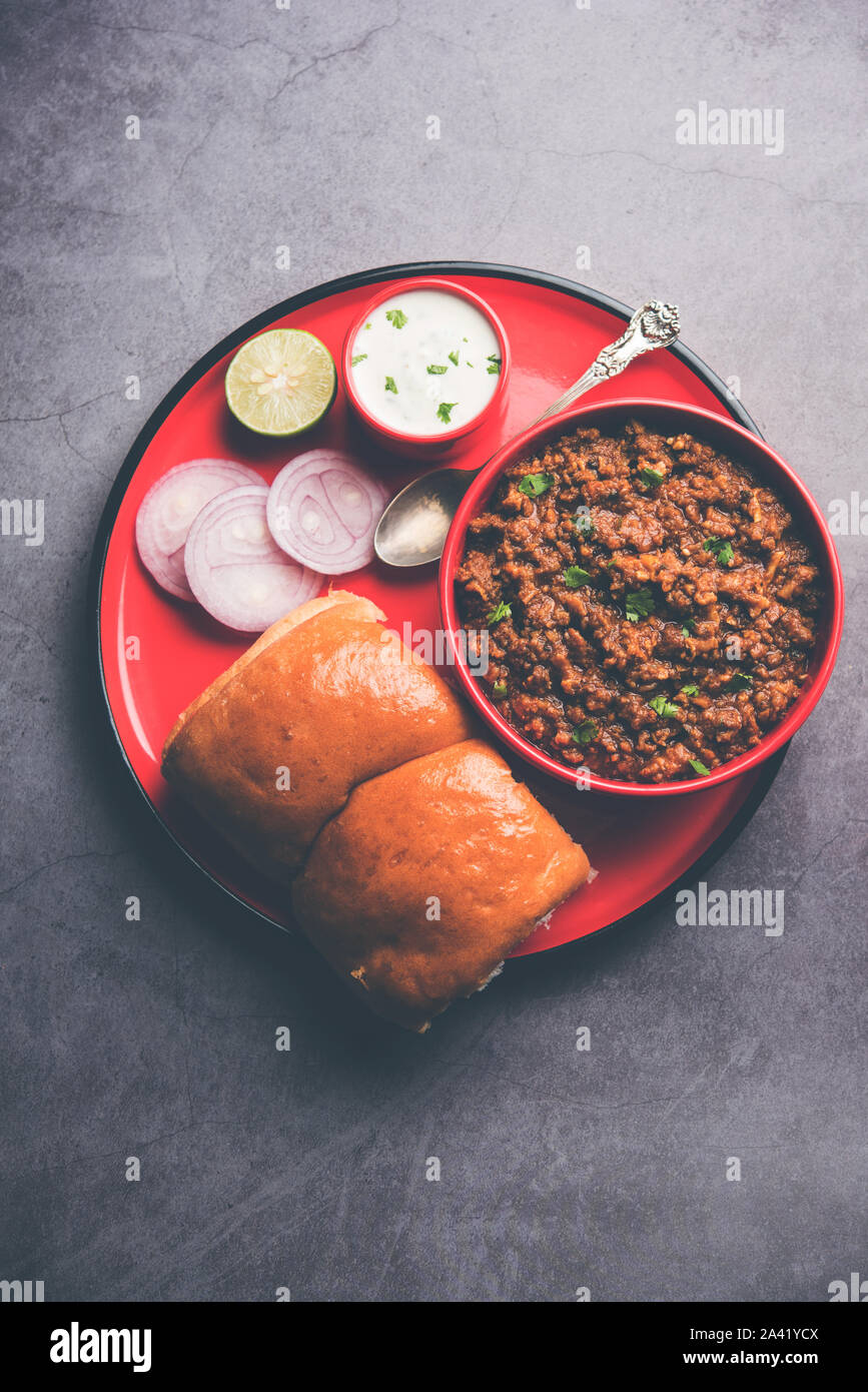 Kheema / keema Pav o Khima Paav è un curry piccante piatto a base di pollo tritato o agnello cotto con cipolla, pomodori, servita con ciambelle. focu selettiva Foto Stock