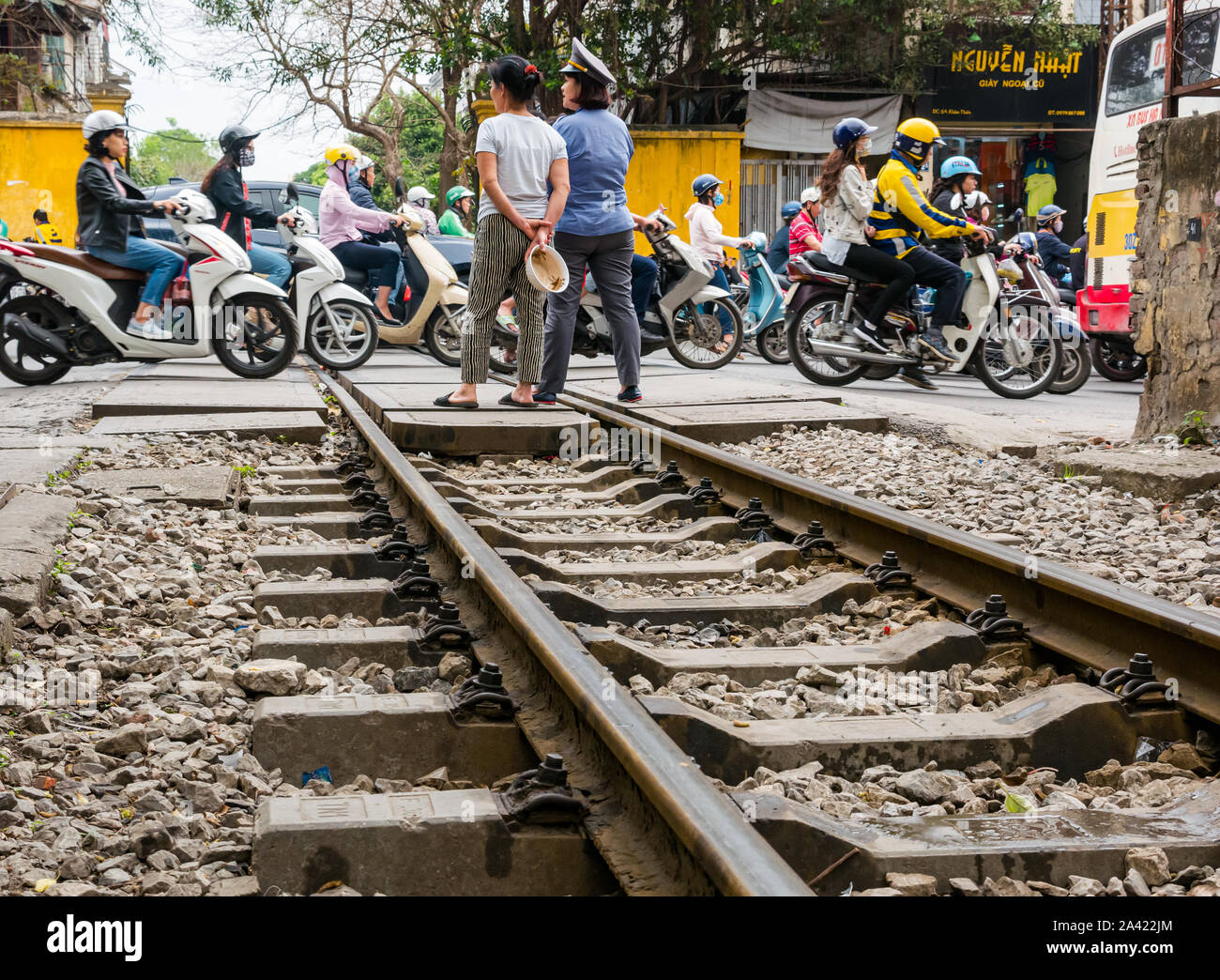 Protezione del treno con scooter e il traffico che attraversa la linea ferroviaria, villaggio ferroviario, Hanoi, Vietnam Asia Foto Stock