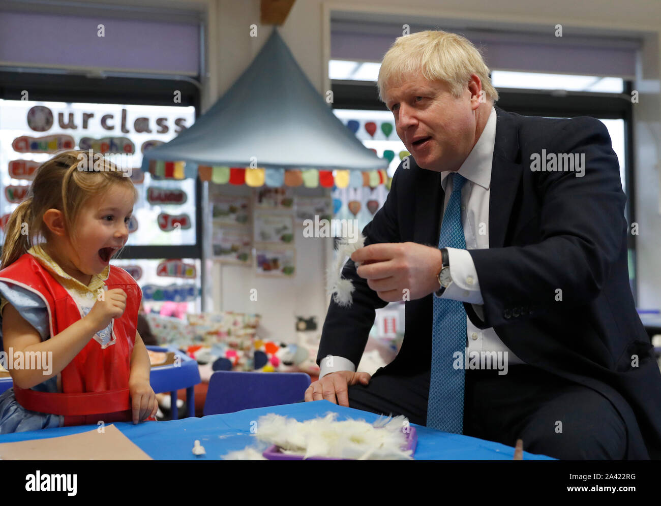 Il primo ministro Boris Johnson gesti come egli partecipa a un arte di classe con quattro anni di Scarlet Fickling durante una visita a St Mary e tutti i santi la scuola primaria a Beaconsfield, Buckinghamshire per un annuncio su assegnazioni di fondi per le scuole in tutta l'Inghilterra. Foto Stock