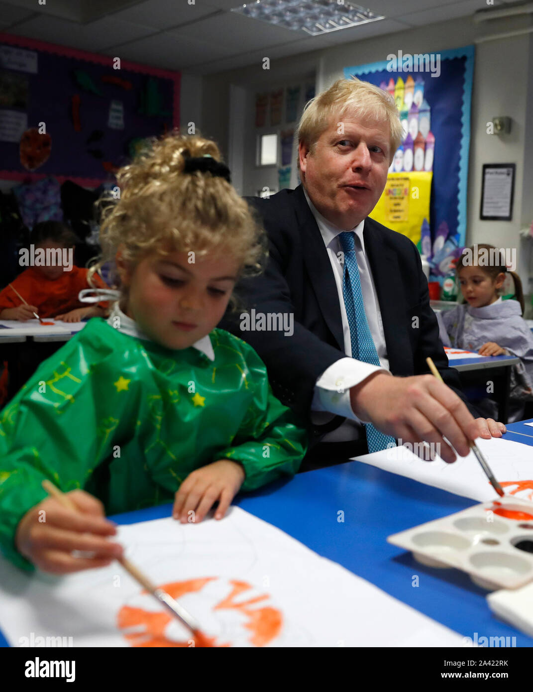 Il primo ministro Boris Johnson gesti come egli partecipa a una classe di arte con Lyla Shepard-Robinson durante una visita a St Mary e tutti i santi la scuola primaria a Beaconsfield, Buckinghamshire per un annuncio su assegnazioni di fondi per le scuole in tutta l'Inghilterra. Foto Stock