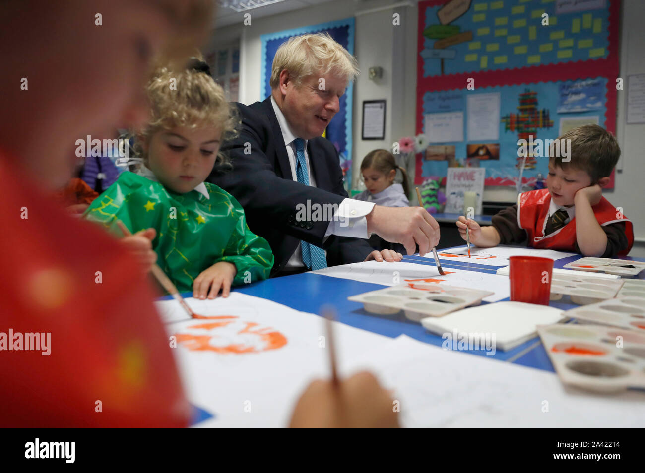 Il primo ministro Boris Johnson gesti come egli partecipa a una classe di arte con Lyla Shepard-Robinson durante una visita a St Mary e tutti i santi la scuola primaria a Beaconsfield, Buckinghamshire per un annuncio su assegnazioni di fondi per le scuole in tutta l'Inghilterra. Foto Stock
