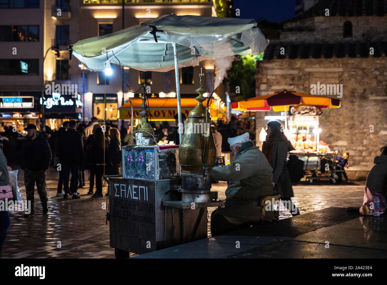 Atene, Grecia - 2 Gennaio 2019: Street anziani venditore in un chiosco di salep, tipica bevanda calda, la notte di Natale nel centro di Atene, Grecia Foto Stock