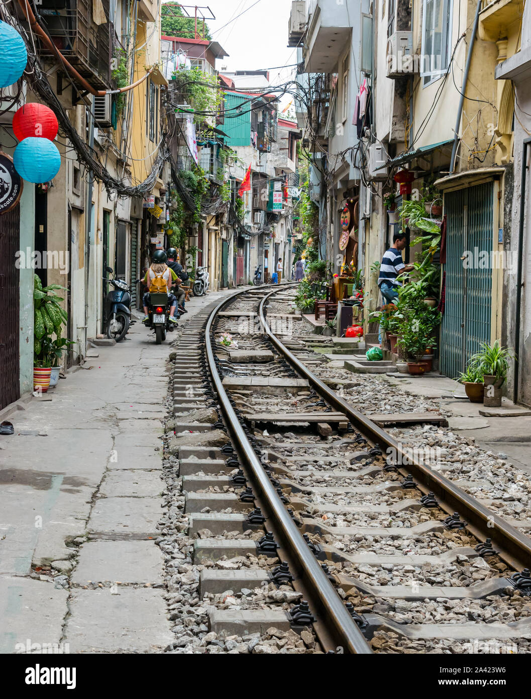 Moto nel villaggio ferroviario o treno Street, una stretta viuzza con linea ferroviaria vicino a vecchie case, Hanoi, Vietnam Asia Foto Stock