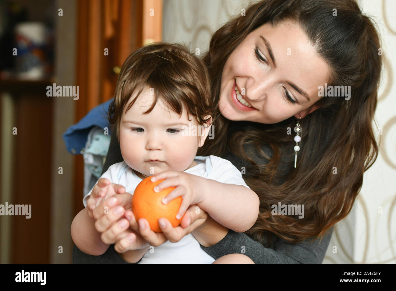 Mom fornisce un arancione per un bambino. le vitamine al bambino. frutta per bambini. sana nutrizione Foto Stock