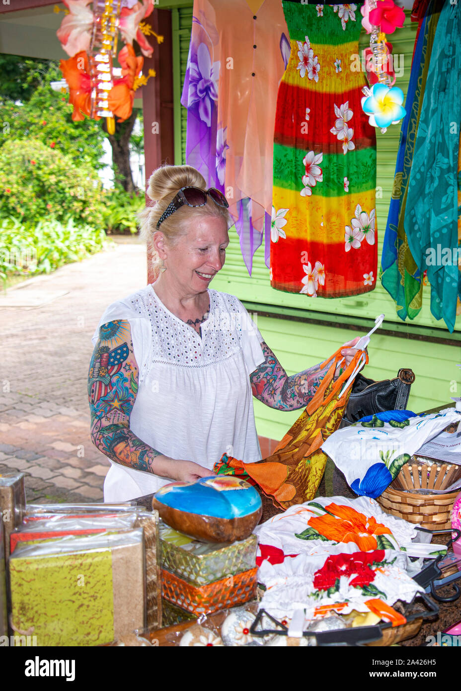 donna di mezza età shopping al mercato locale nelle Seychelles, guardando i bei tessuti multicolore al piccolo Stand, Victoria, Seychelles, Foto Stock