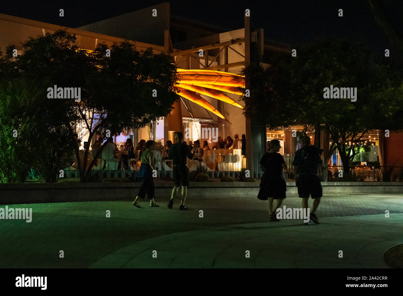 Le coppie a piedi da un ristorante dove la gente per cenare in un patio all'aperto nel centro di Scottsdale. Foto Stock