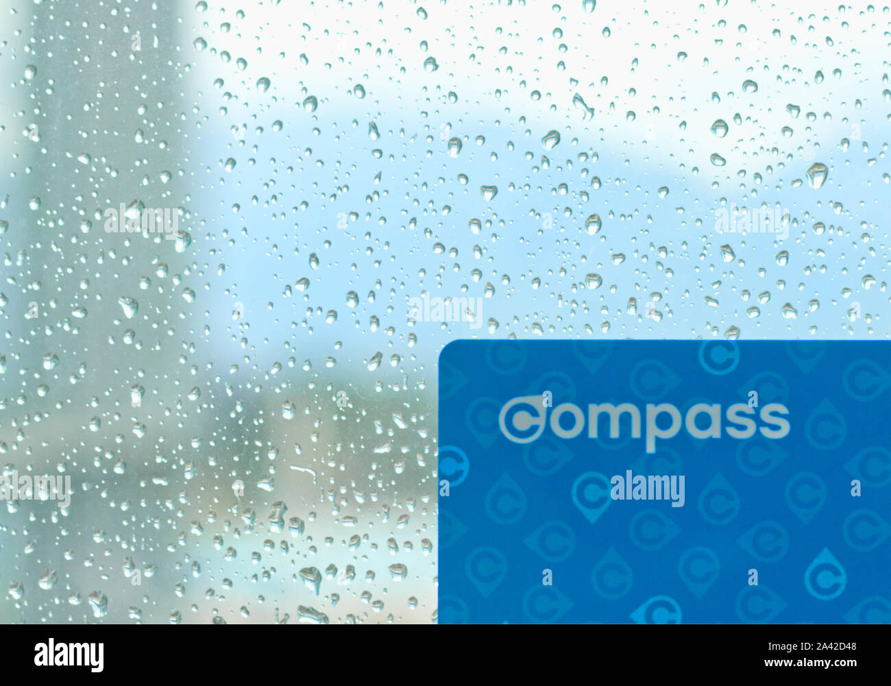 Vancouver, Canada - 12 Settembre 2019: Bussola scheda contro il vetro con l'acqua scende su di essa durante le piogge di Vancouver Foto Stock