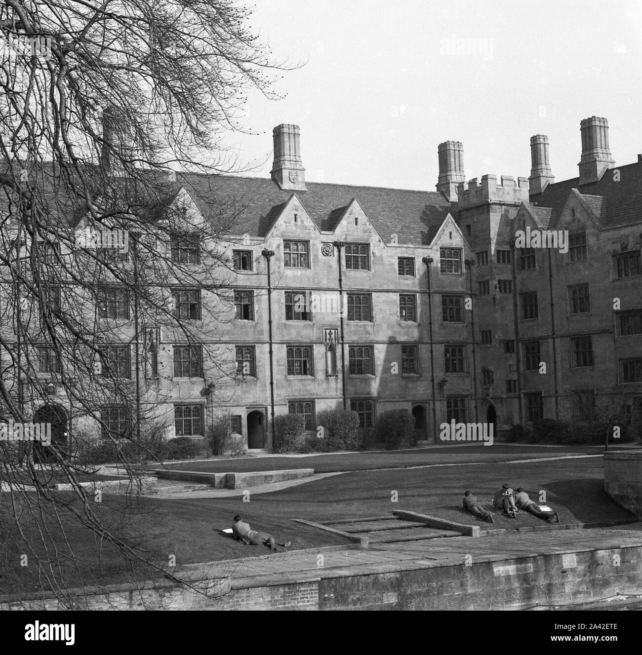 1953, historial, esterno dell edificio antico, l'Università di Cambridge, Inghilterra, Regno Unito, studenti sdraiati sull'erba al di fuori del college dal fiume Cam. Foto Stock