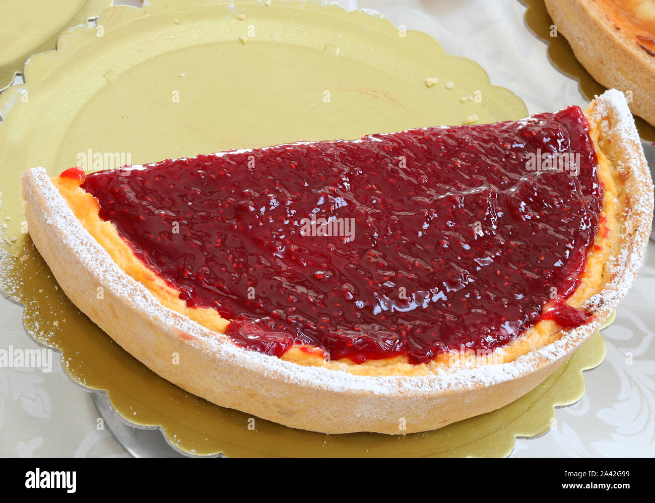 Mezza torta con marmellata con rosso lampone e fragole Foto Stock