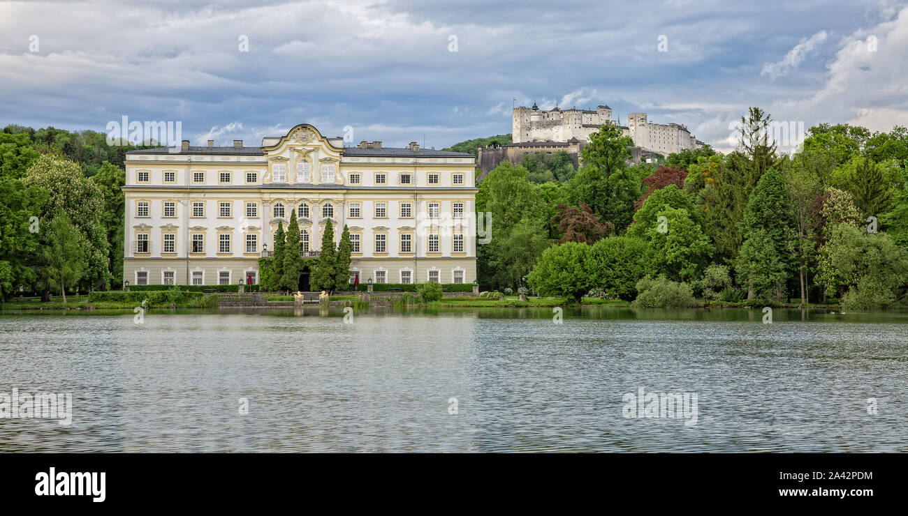 Ottima vista su Festung Hohensalzburg, Schloss Leopoldskron e il Leopoldskroner Weiher in Salzburg al tramonto, Austria Foto Stock