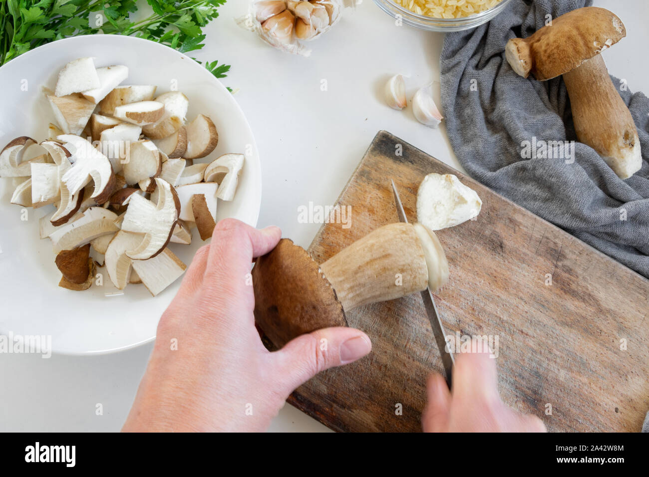 Punto di vista personale della donna le mani la preparazione di funghi porcini (Boletus commestibile) per la cottura Foto Stock