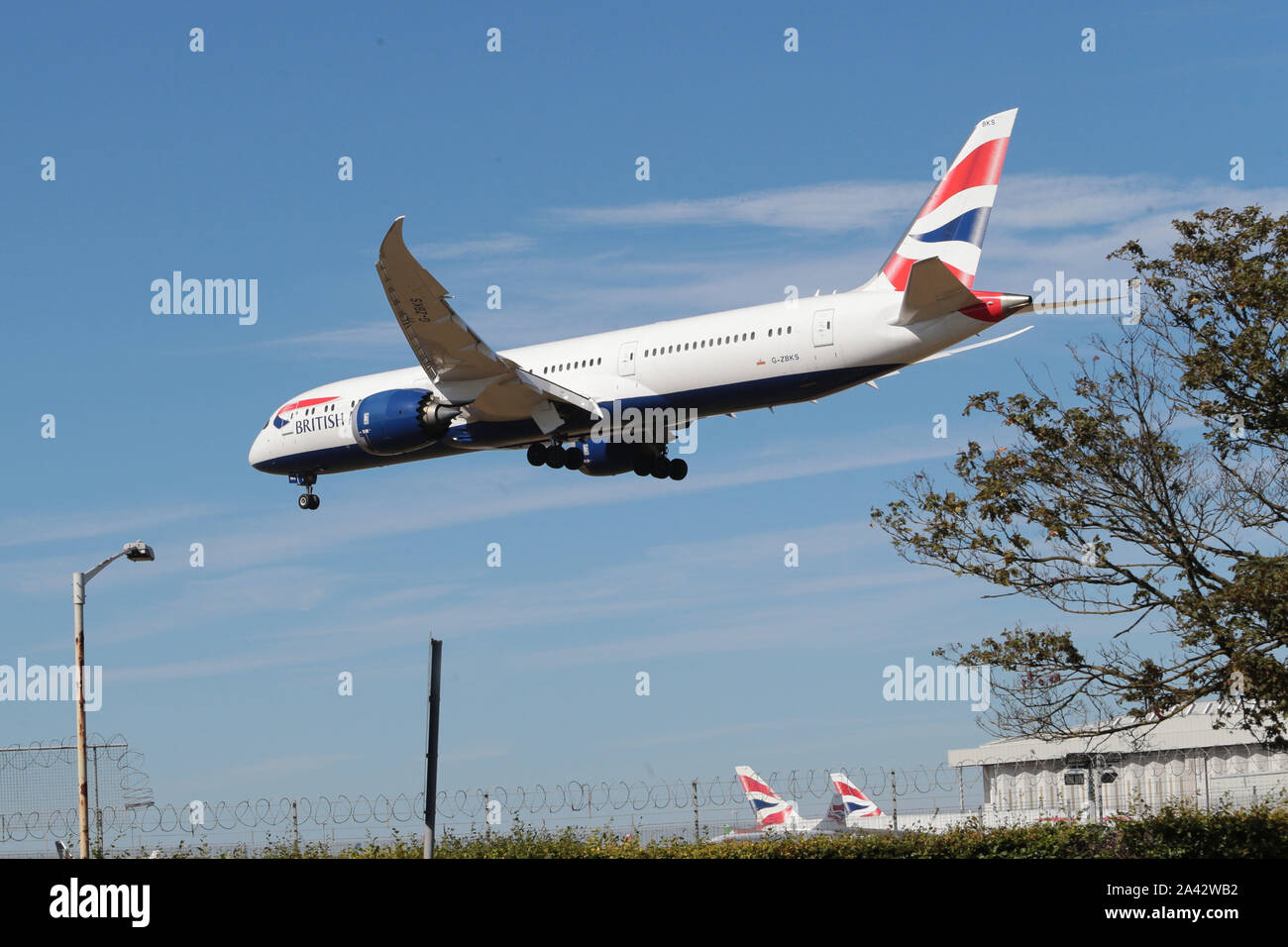 In uscita del cielo blu con sotto il carrello che scende a terra all'Aeroporto Heathrow di Londra nel Regno Unito Foto Stock