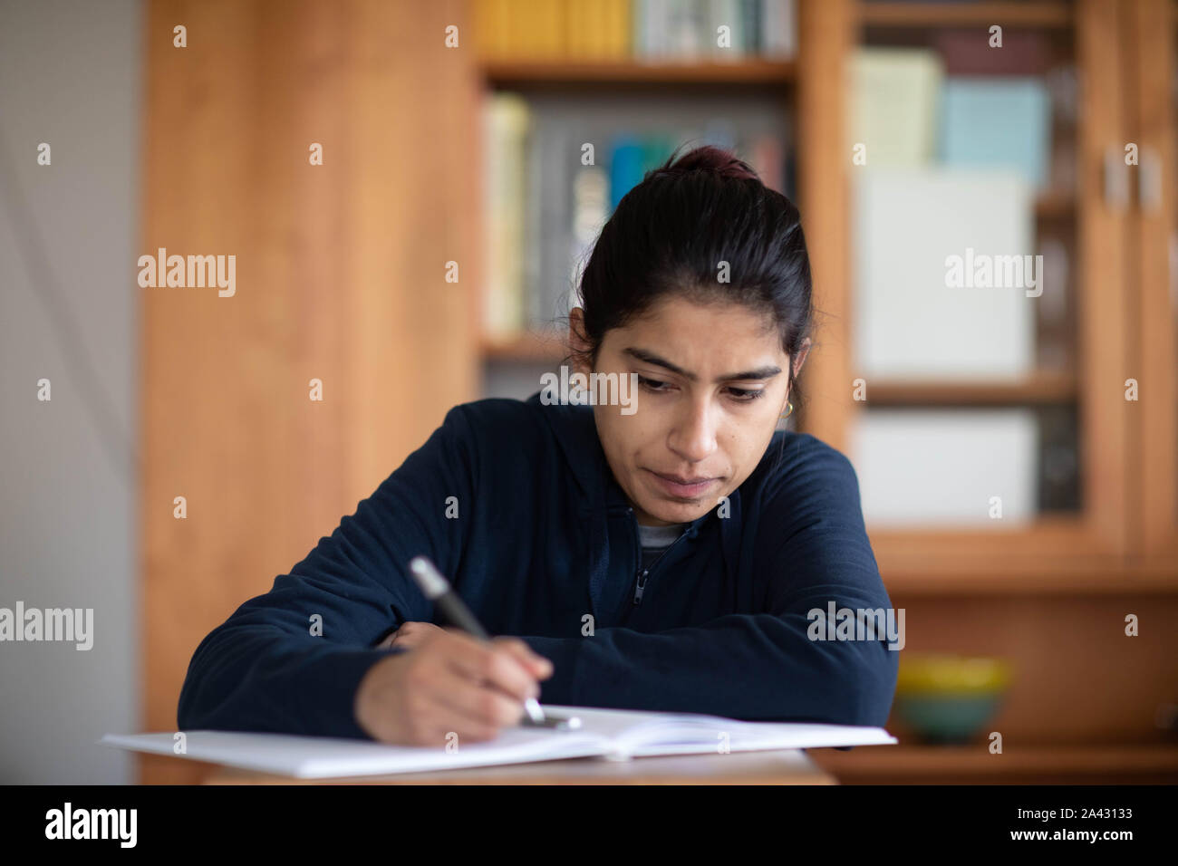 Stundent yong donna apprendimento in una stanza Foto Stock