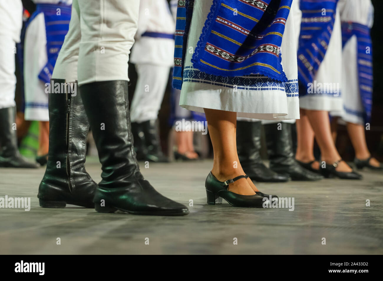 In prossimità delle gambe del giovane rumeno maschi e femmine di ballerini in tradizionale costume folkloristico. Il folklore della Romania Foto Stock