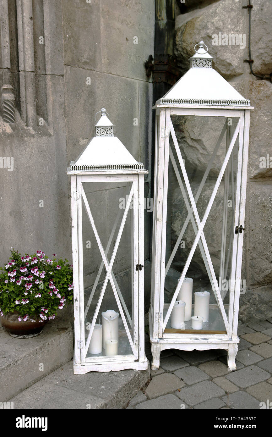 Due grandi bianche di vecchio stile lanterne di legno nei pressi della  vecchia casa di pietra sulla strada. Vaso con fiori Foto stock - Alamy