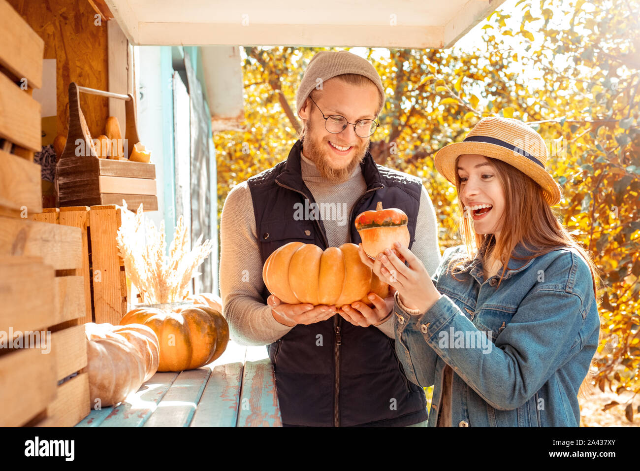 Halloween Preparaton concetto. Coppia giovane decorare casa con zucche guardando harvest giocoso Foto Stock