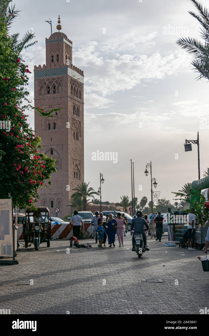 Il Marocco. Strada con persone in Marrakech con Moschea Koutoubia Mosque in background, in ottobre 2019. Foto Stock