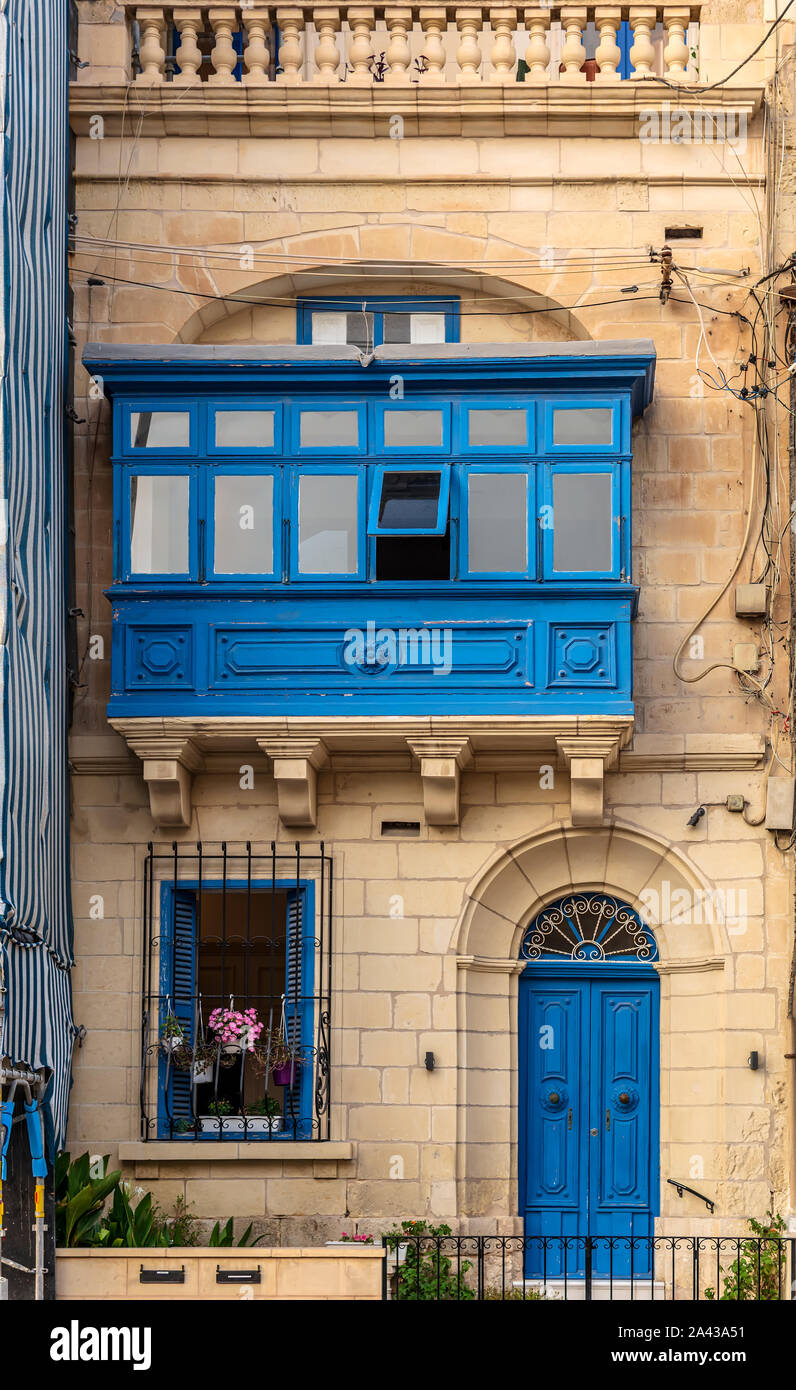 Casa residenziale facciata con blue door, persiane alle finestre e il tradizionale maltese in legno balcone racchiuso in Sliema Malta. Foto Stock