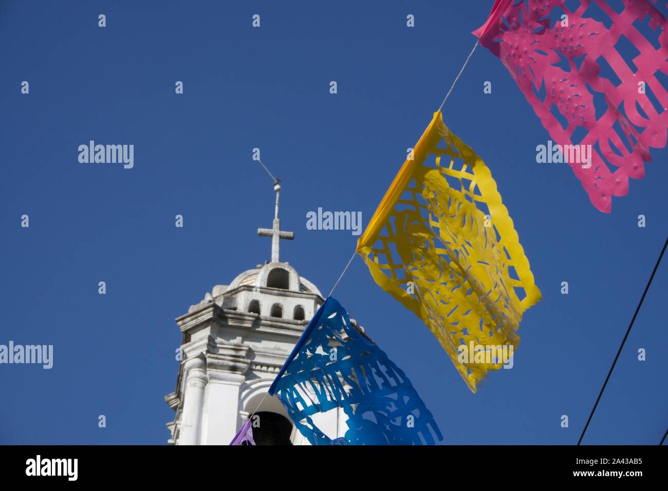 La Iglesia de Santa Ana, Chiesa di Santa Ana, Barrio de Peralvillo, a Cuauhtémoc. Papel picado (taglio carta bandiere) e il campanile con la croce. Città del Messico. Foto Stock