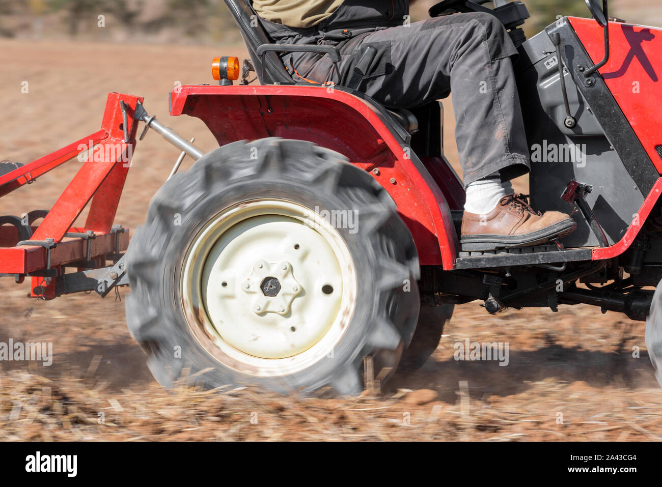 Trattore rosso con Aratro assolcatore terreno del campo vicino la vista . Foto Stock