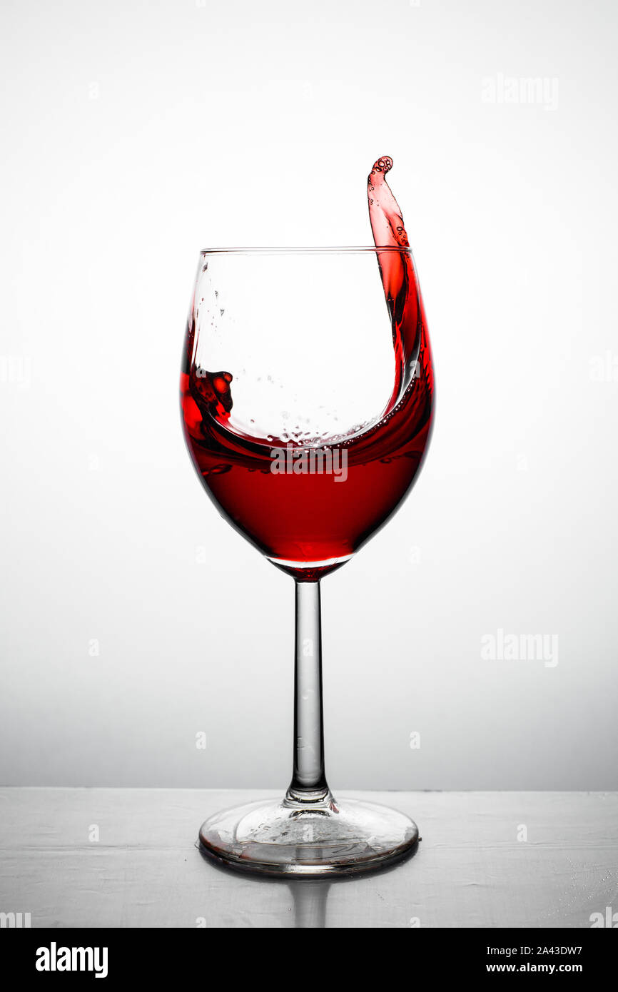 Vino rosso fino agli spruzzi e da un vetro Foto Stock