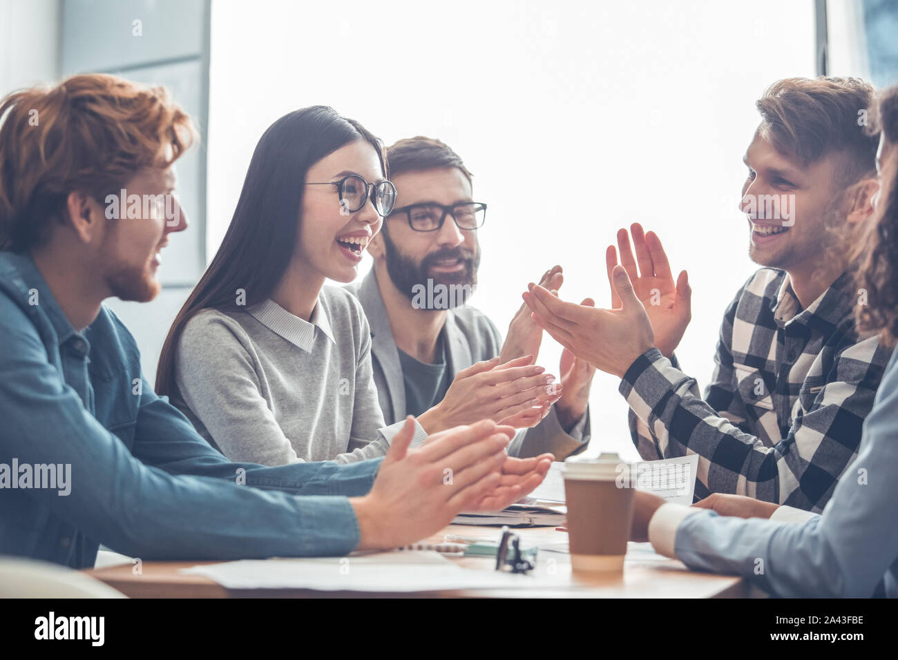 Startupers lavorando insieme in ufficio di affari battimani ot ogni altra gioiosa Foto Stock
