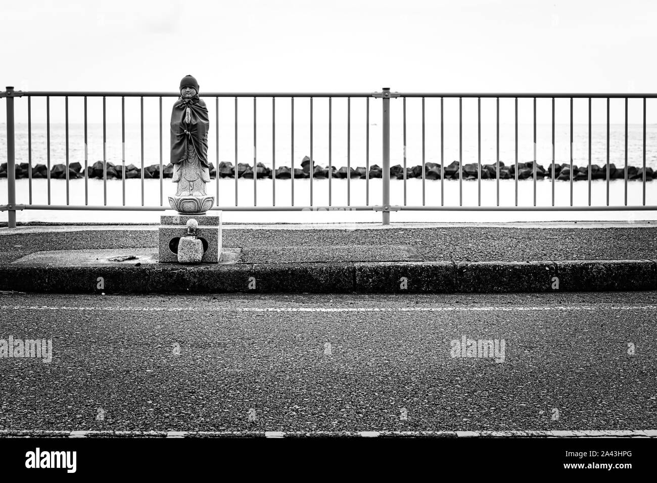 Appena a sud di Yokosuka, Giappone sulla Baia di Tokyo in Nobi siede questo piccolo santuario stradale sul cordolo della strada costiera. Foto Stock
