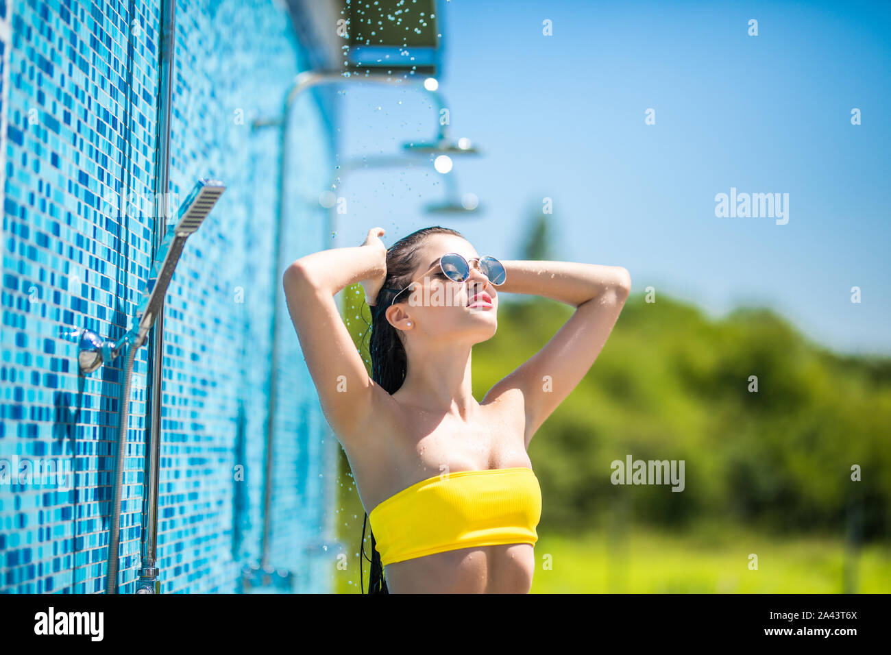 Donna in costume da bagno la doccia dopo una nuotata in piscina e il mare,  in un caldo giorno d'estate e di sole Foto stock - Alamy