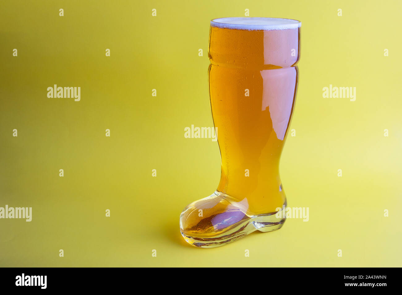 La birra nel bagagliaio di un bicchiere di birra in sfondo giallo Foto Stock