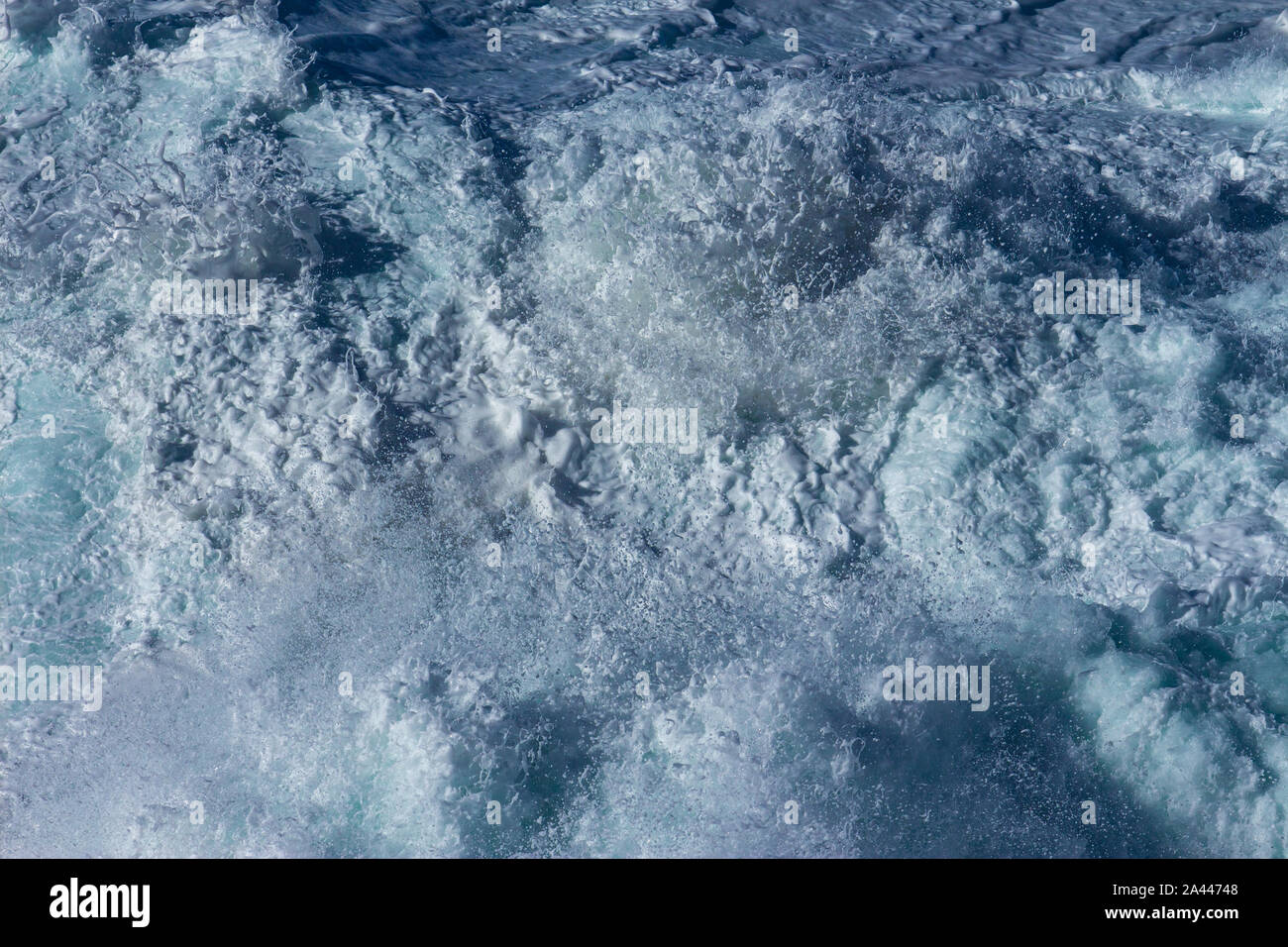 Aquatic sullo sfondo di un mare di onde da surf spruzzi chiudere con chiaro blu verde acqua e schiuma bianca Foto Stock