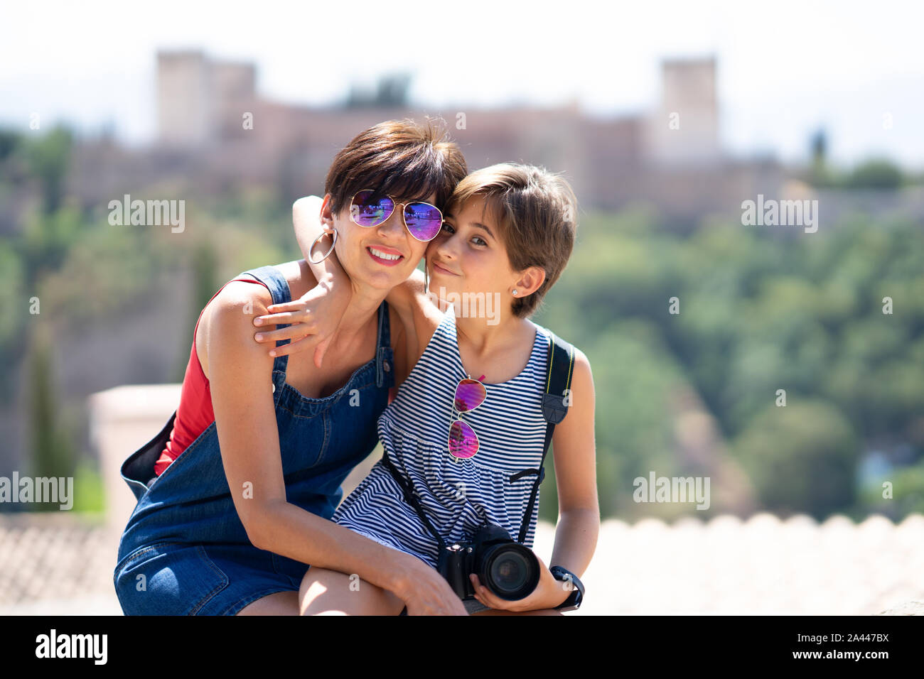 Sua madre e la sua piccola figlia che viaggiano insieme in background urbano. Foto Stock