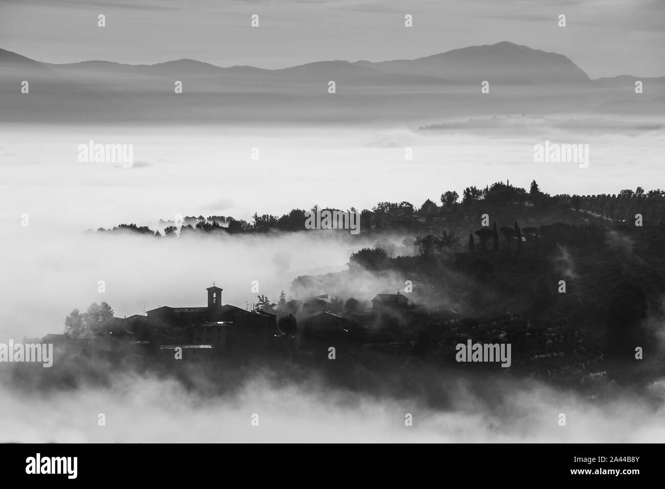 Surreale in vista di una piccola città in Umbria (Italia) quasi completamente nascosto dalla nebbia. Foto Stock