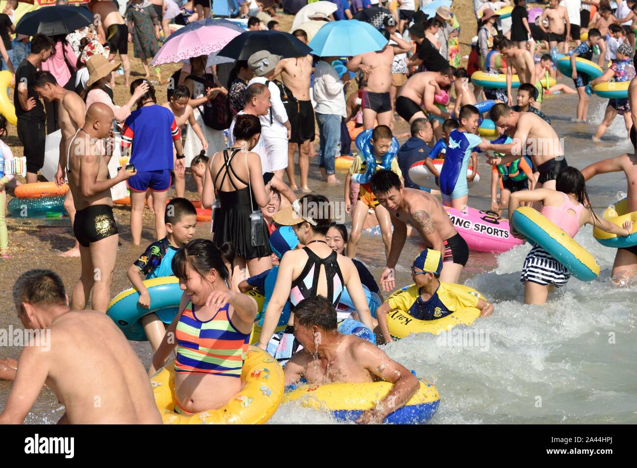 Visitatori sciame alla locale sea resort dopo il tifone Lekima di Dalian, a nord-est della Cina¯s provincia di Liaoning, 18 agosto 2019. Foto Stock