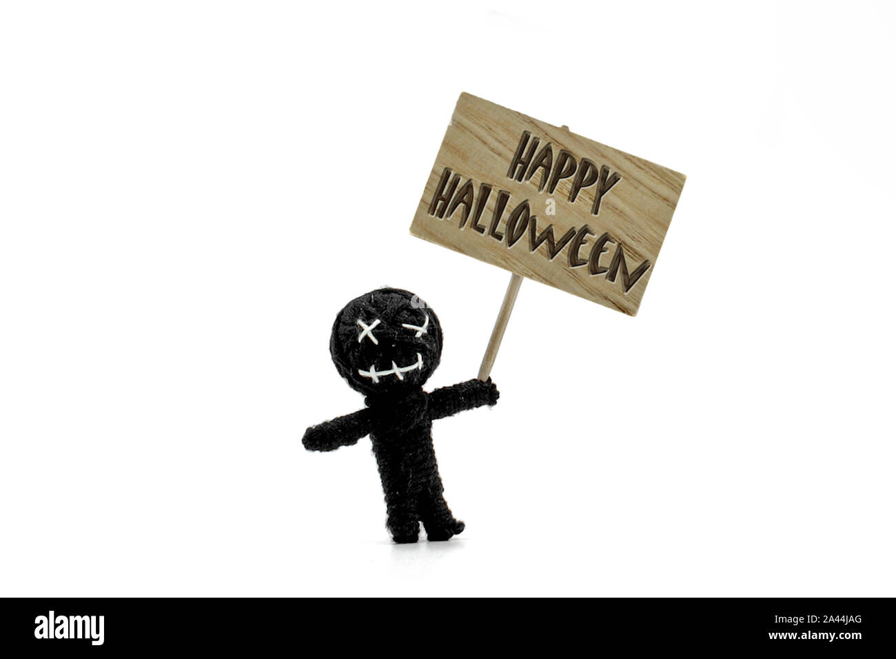 Happy Halloween messaggio sul cartello in legno nero con voodoo doll isolati su sfondo bianco Foto Stock