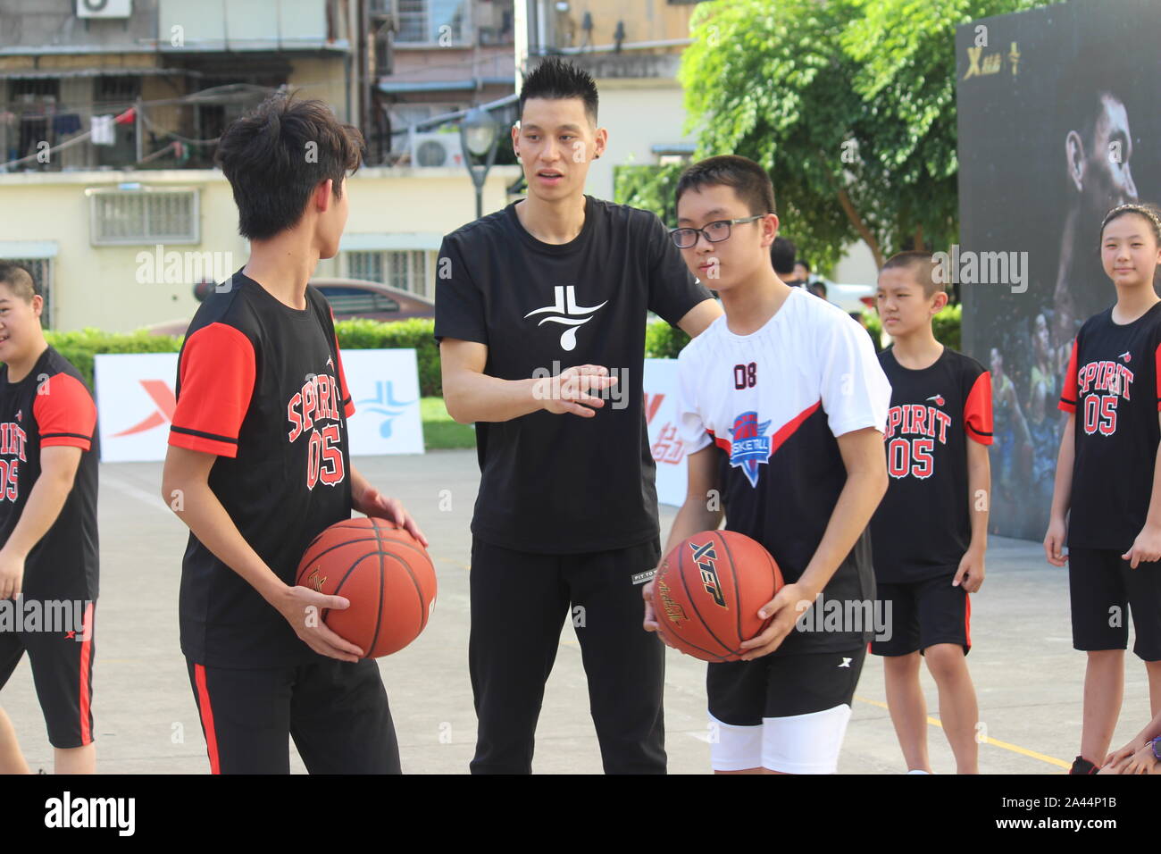 Jeremy Shu-How Lin, o semplicemente Jeremy Lin, medio, insegna ai bambini il basket per festeggiare il suo trentunesimo compleanno nella città di Fuzhou, a sud-est della Cina di Fujian Foto Stock