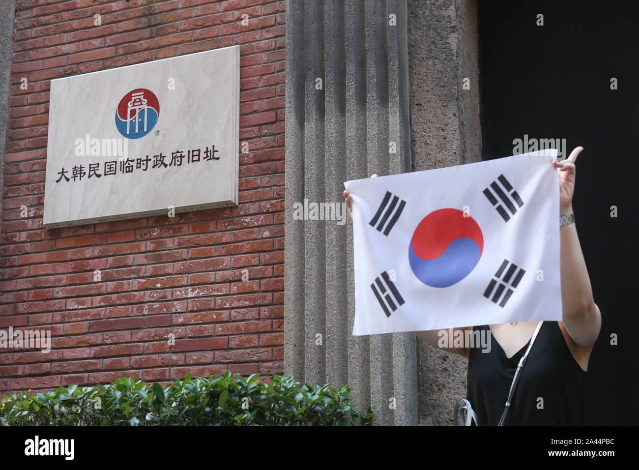 Un sud coreano pone turistiche per le foto con la sua bandiera nazionale di fronte al sito del coreano Governo provvisorio per saperne di più circa la histo Foto Stock