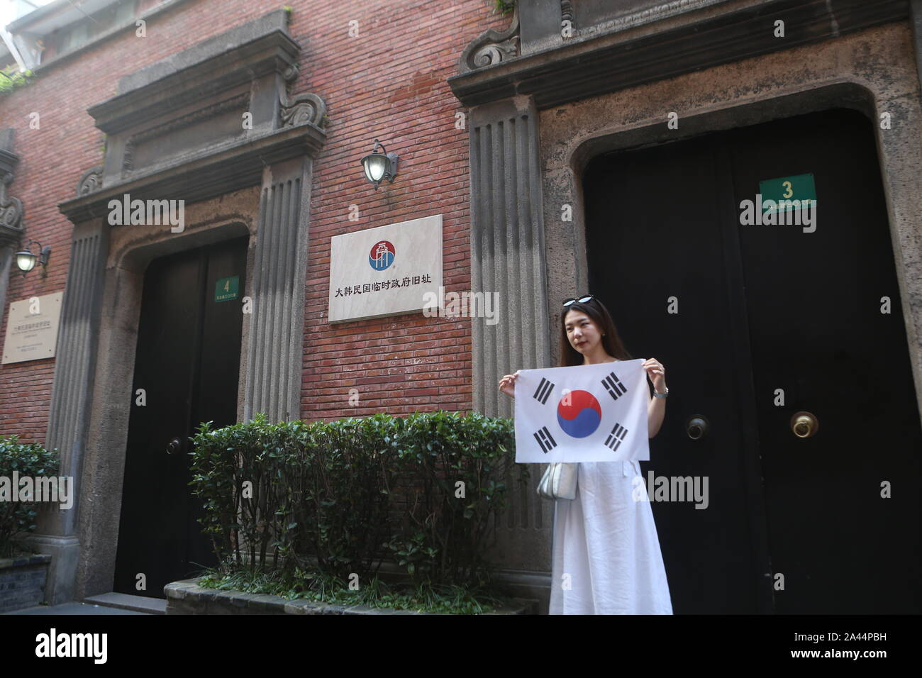 Un sud coreano pone turistiche per le foto con la sua bandiera nazionale di fronte al sito del coreano Governo provvisorio per saperne di più circa la histo Foto Stock