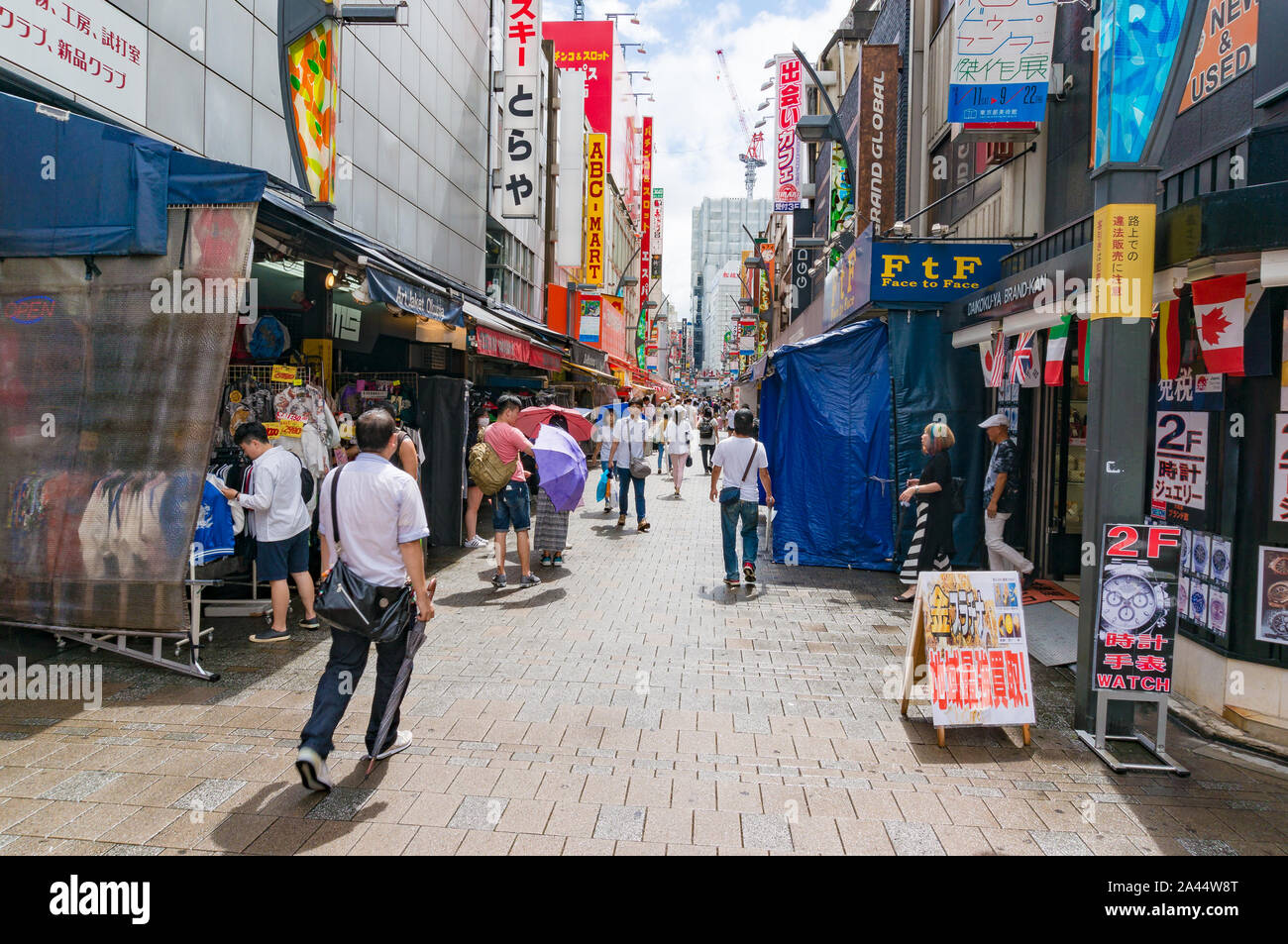 Tokyo, Giappone - 29 agosto 2016: mercato Ameyoko vicolo, street con il venditore si spegne e la folla di gente. Banner in giapponese pubblicizza orologi, custom mad Foto Stock