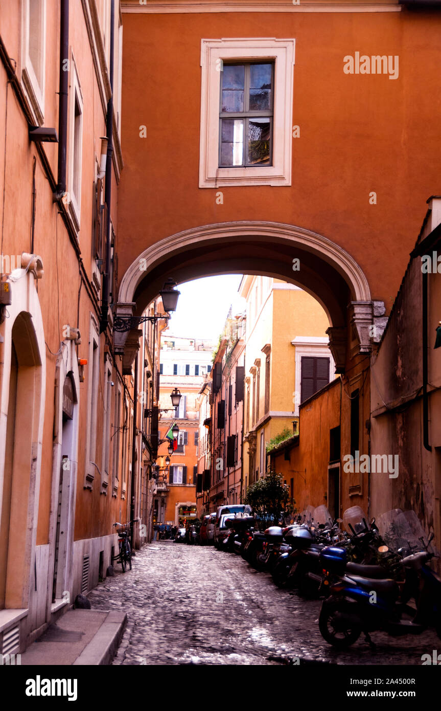 Arco coperto su una strada lastricata a Roma, Italia. Foto Stock