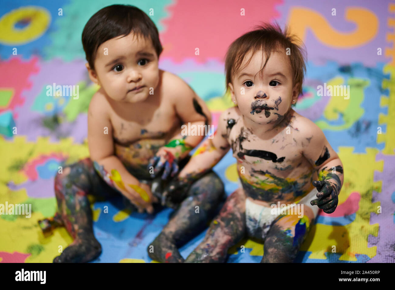 Bambini giocano con vernice colorata e rendere il disordine Foto Stock