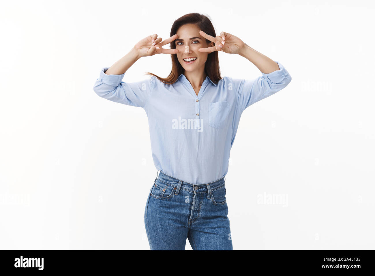 Felice spensierato di mezza età sentimento donna upbeat rilassata fatta tatuare pace mostra segni di vittoria sugli occhi, sorridente largamente, esprimere la gioia di positività, godetevi Foto Stock