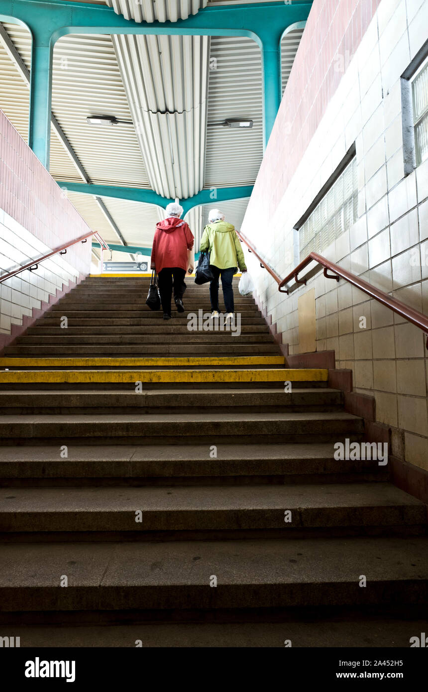 due donne anziane che camminano al piano superiore in una stazione ferroviaria Foto Stock
