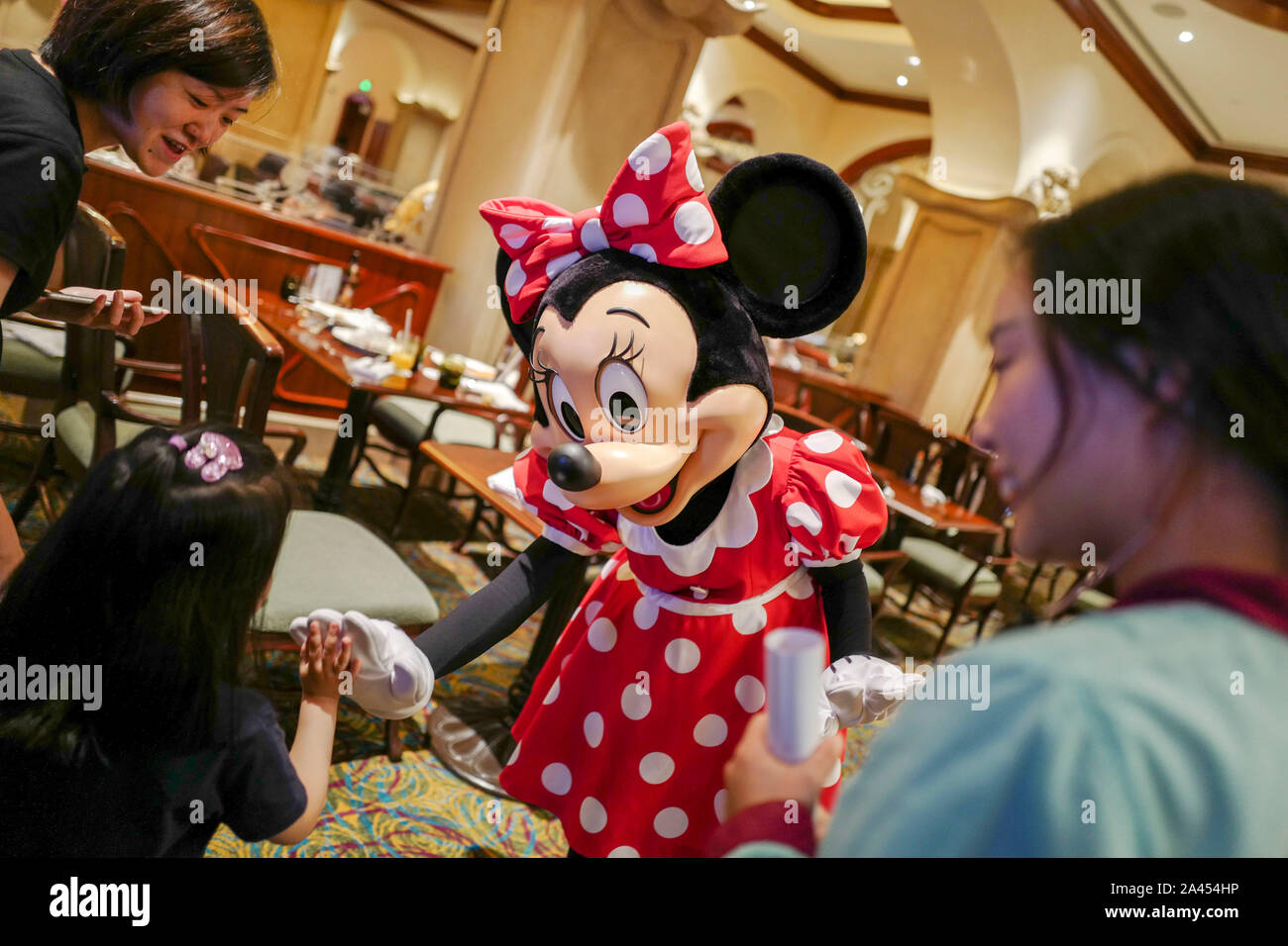 --FILE--Minnie Mouse interagisce con un bambino in un ristorante a Shanghai Disneyland a Shanghai in Cina, 11 luglio 2019. La query ha recentemente sollevato rel Foto Stock