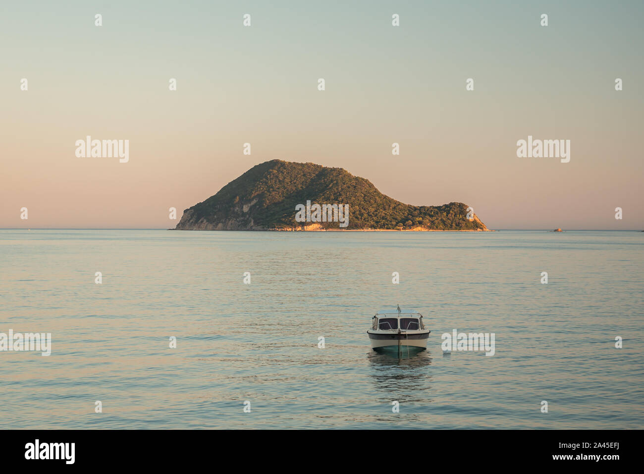 Vista dal mare di Marathonisi o Turtle Island vicino isola greca di Zante nel Mar Ionio wuht una barca di fronte ad esso. Foto Stock