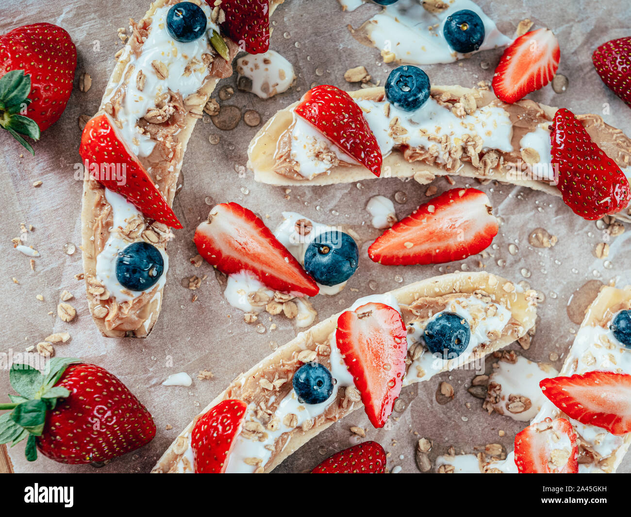 Banana Split con fragole, mirtilli, burro di mandorla e miele Foto Stock