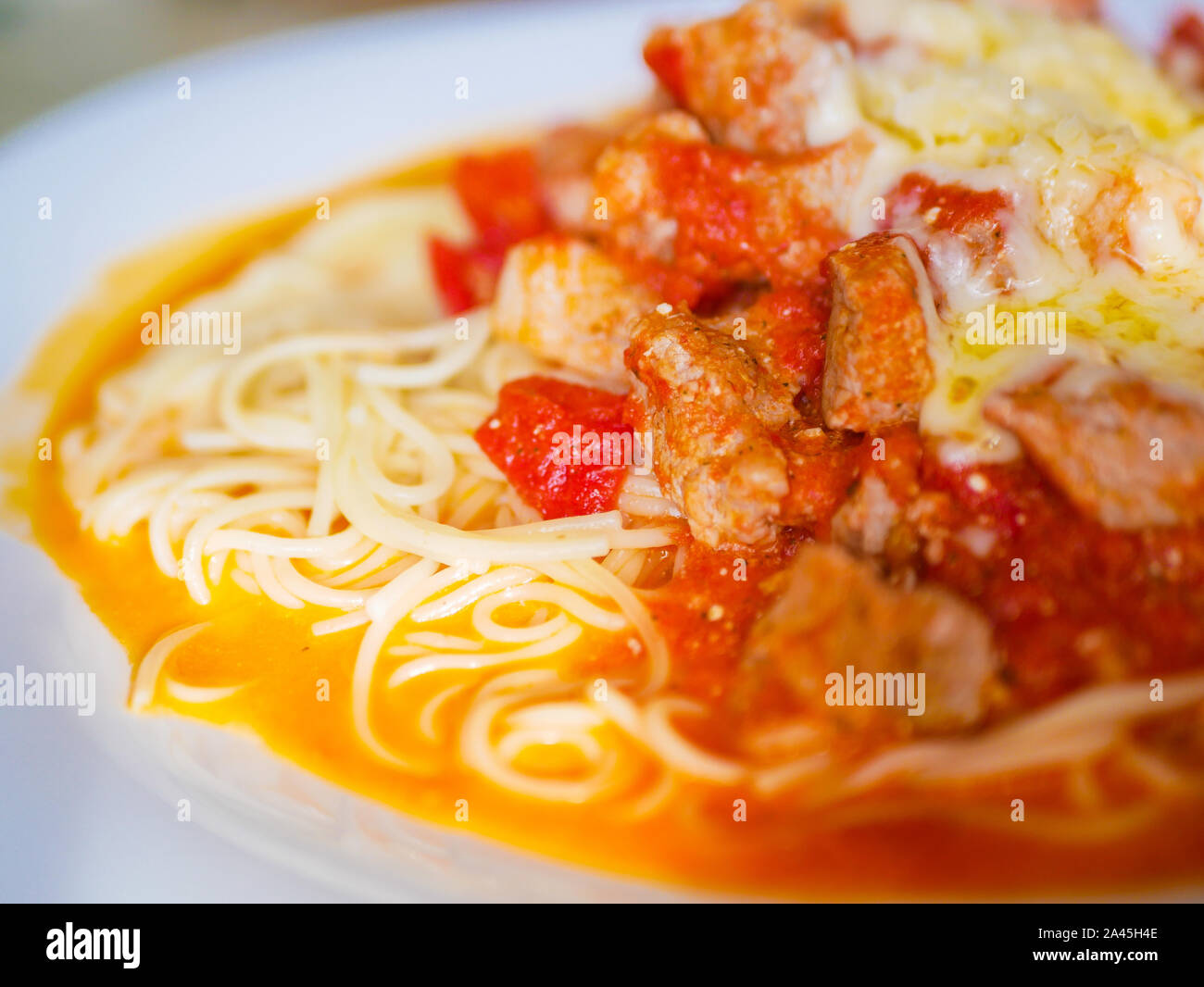 Pasta con carne e i pomodori su una piastra bianca Foto Stock